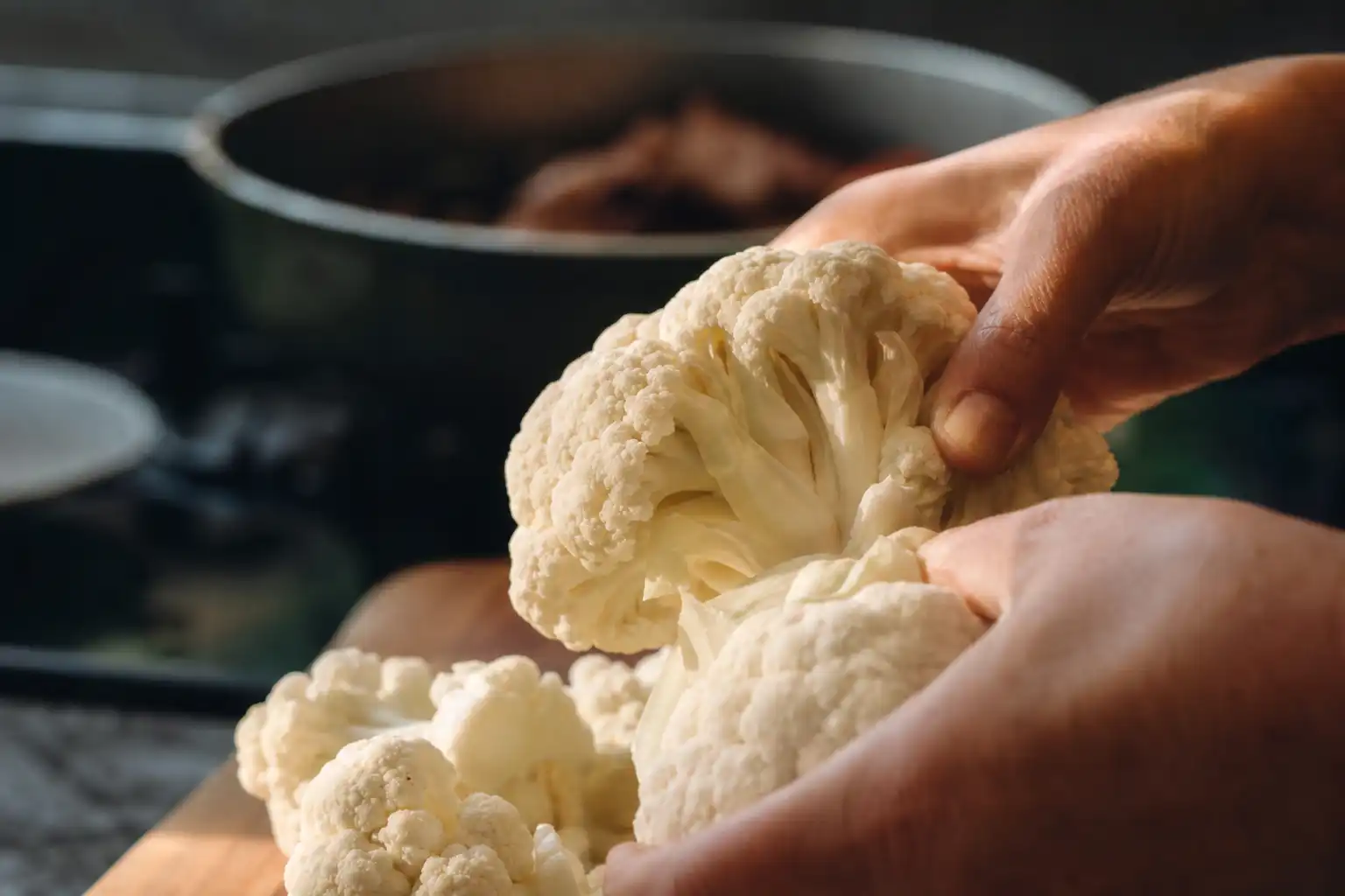Des mains manipulent un objet, autour d'actualités, dans une cuisine.